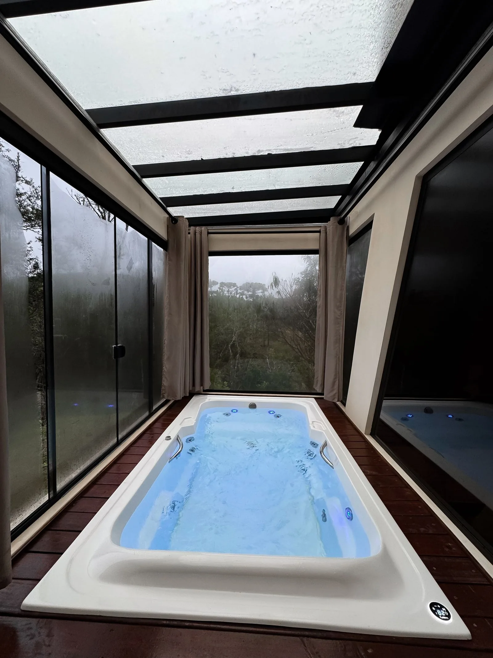Modern indoor hot tub under a glass roof, the kind of spa whose cartridge filter needs regular cleaning